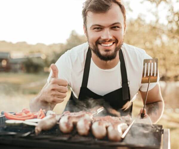 caterer smiling thumbs up while grilling