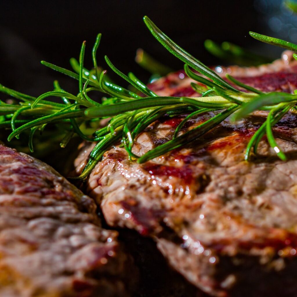 A close-up of barbequed meat with greens